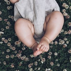 Low section of baby sleeping on flowering plants