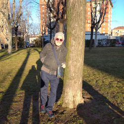 Portrait of boy standing by tree trunk