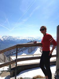 Man standing on snowcapped mountain against sky