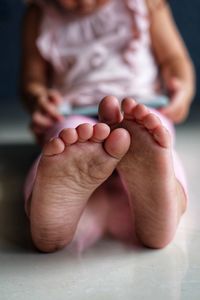 Low section of girl using digital tablet while sitting on floor