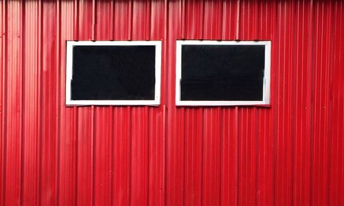 Windows on red corrugated wall