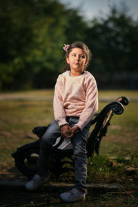 Portrait of young woman sitting on field