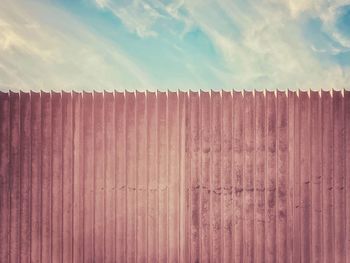 Low angle view of wooden fence against sky