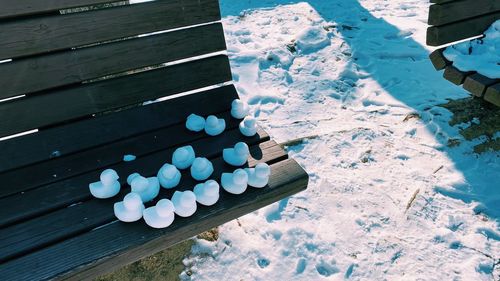 High angle view of snow balls on bench outdoors