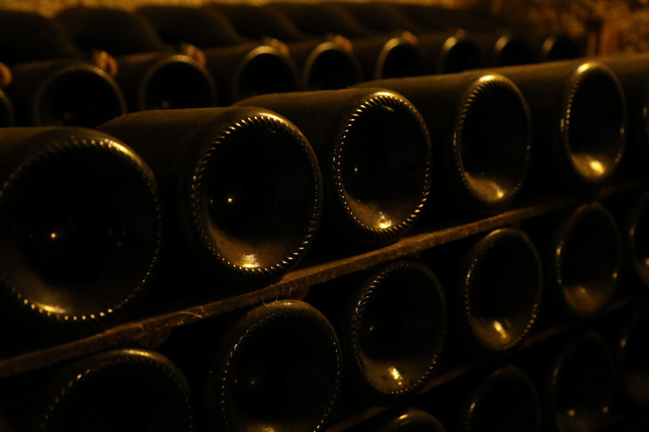 FULL FRAME SHOT OF WINE BOTTLES IN SHELF