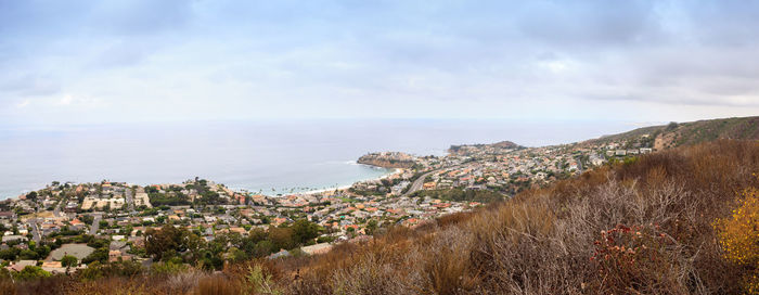 Scenic view of town by sea against sky