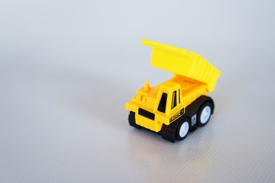 Close-up of yellow toy car over white background