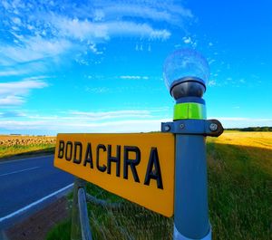 Information sign on road against blue sky