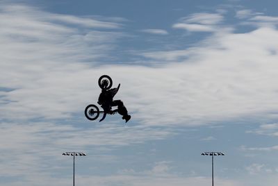 Man performing extreme stunt with motorcycle in mid-air