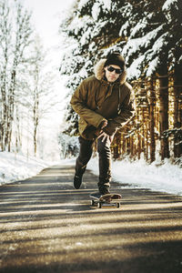 Full length of man standing on snow covered road