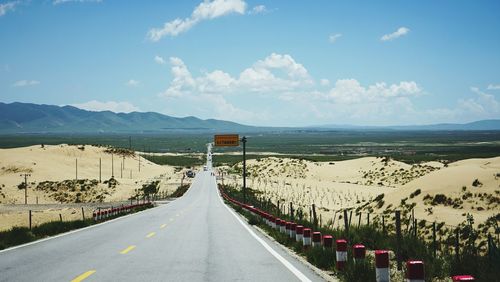Panoramic view of road leading towards mountains against sky