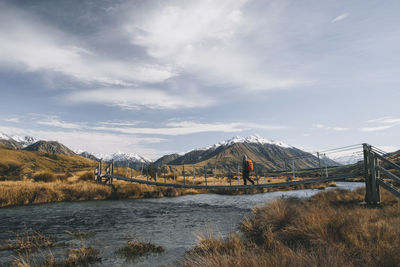 Scenic view of lake by snowcapped mountains against sky