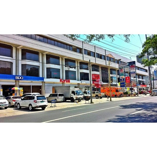 building exterior, architecture, built structure, transportation, car, land vehicle, street, mode of transport, city, road, transfer print, city life, city street, building, incidental people, road marking, auto post production filter, clear sky, day, travel