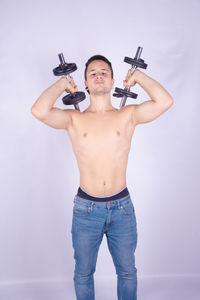 Portrait of young man with arms outstretched against white background