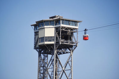 Low angle view of communications tower against clear blue sky