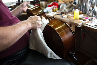 Midsection of woman cleaning violin