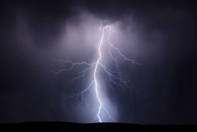 A lightning bolt illuminates rain falling from a thunderstorm near kearny, arizona.