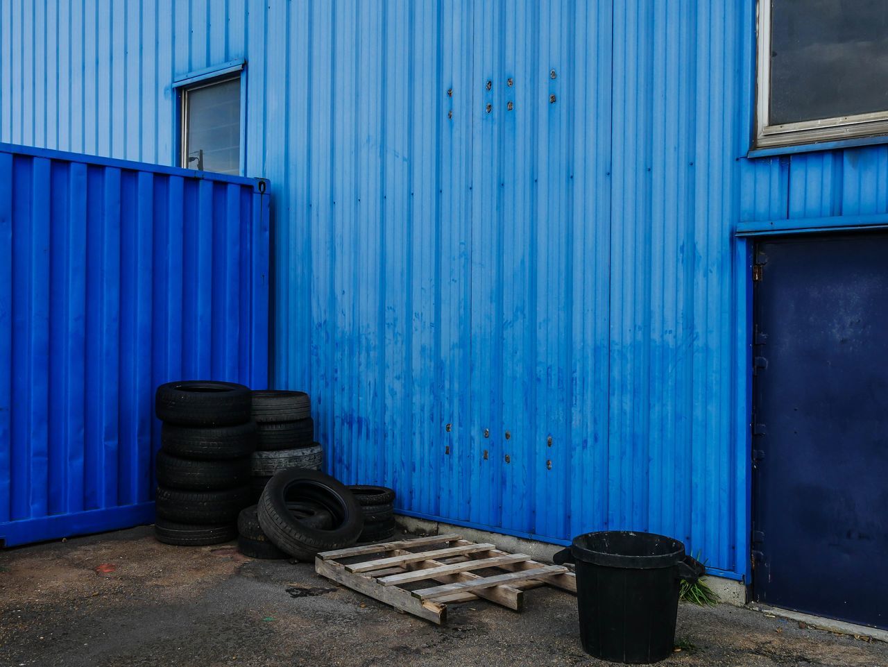 blue, architecture, no people, built structure, metal, building exterior, day, entrance, door, wall - building feature, garage, closed, building, iron, corrugated iron, industry, wheel, wood - material, container, outdoors, corrugated, tire