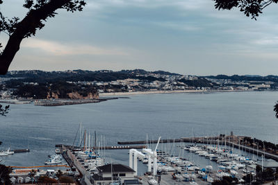 High angle view of bay and cityscape against sky