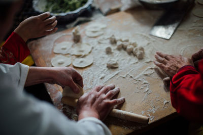 Cropped hands making cookies on table at home