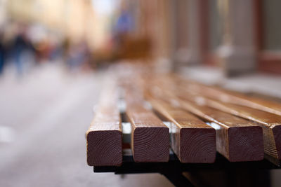 Close-up of wooden bench in city