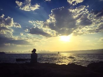 Silhouette man on beach against sky during sunset