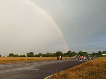 Scenic view of rainbow over road against sky
