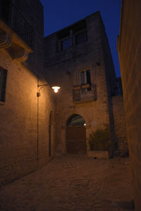 Street amidst buildings at night