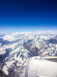 Aerial view of clouds over landscape seen through airplane window