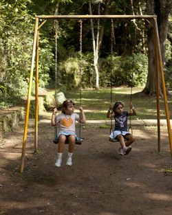 Children playing on swing at playground