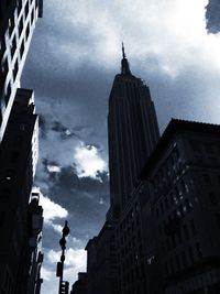 Low angle view of buildings against cloudy sky