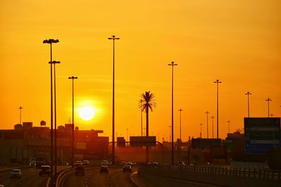 Cars on street against orange sky