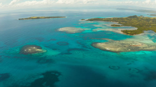 Islands are surrounded by an atoll and a coral reef with blue water top view. bucas grande