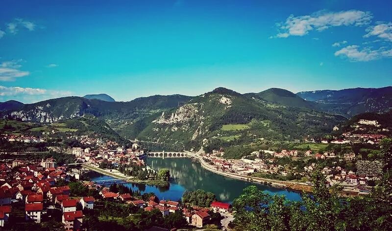 mountain, building exterior, architecture, built structure, cityscape, high angle view, city, crowded, mountain range, residential district, town, sky, blue, townscape, tree, residential structure, water, residential building, house, river