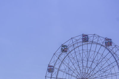 Low angle view of ferris wheel against blue sky