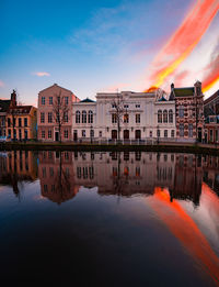 Reflection of buildings in lake during sunset