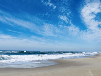 Scenic view of beach against blue sky