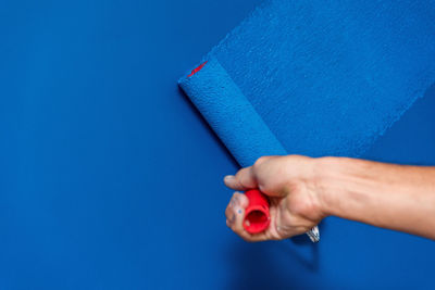 Close-up of woman hand on blue background