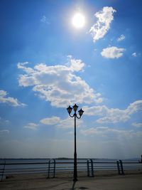 Street light by sea against sky