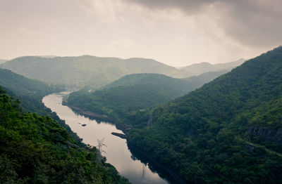 Scenic view of river amidst mountains against sky