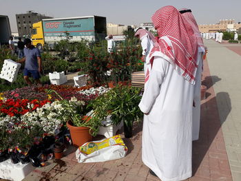 Rear view of woman standing by flowers