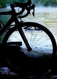 Close-up of bicycle by river against sky