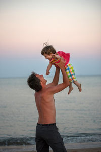 Full length of father with son standing at beach