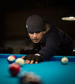 Portrait of young man playing pool table