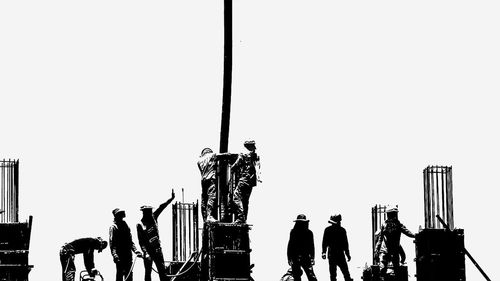 Low angle view of silhouette people against clear sky