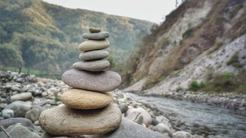 Nature theories, uttarakhand, india- bokeh of weathered pebble stone stacked by shore