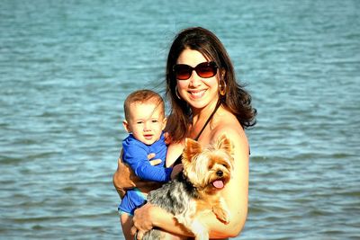 Portrait of smiling woman with dog in sea