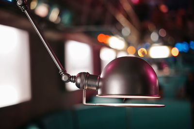 Close-up of illuminated electric lamp on table