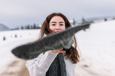 Portrait of young woman standing on snow