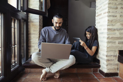 Young man using mobile phone at home